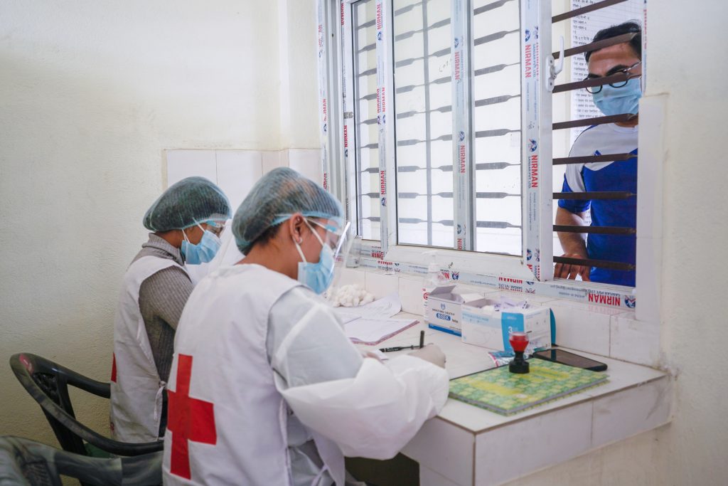 Red Cross volunteers provide support in more than 238 vaccination centres around Nepal, largely focusing on data entry and enforcing the health safety protocols. Photo by Bakash Kari