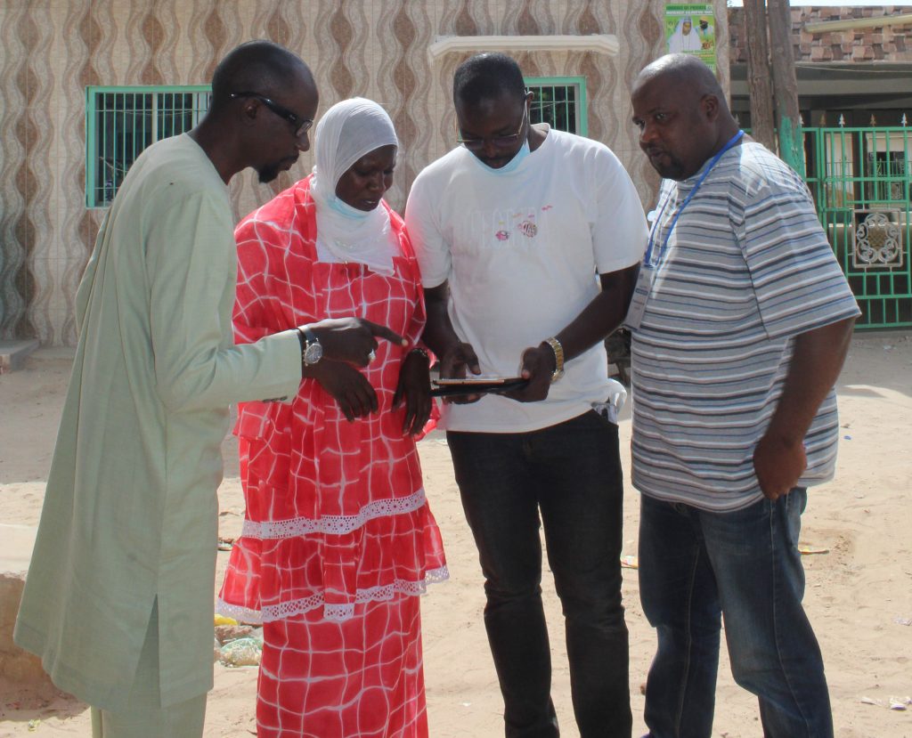 Field workers looking at the Flood Resilience Measurement for Communities (FRMC) App.