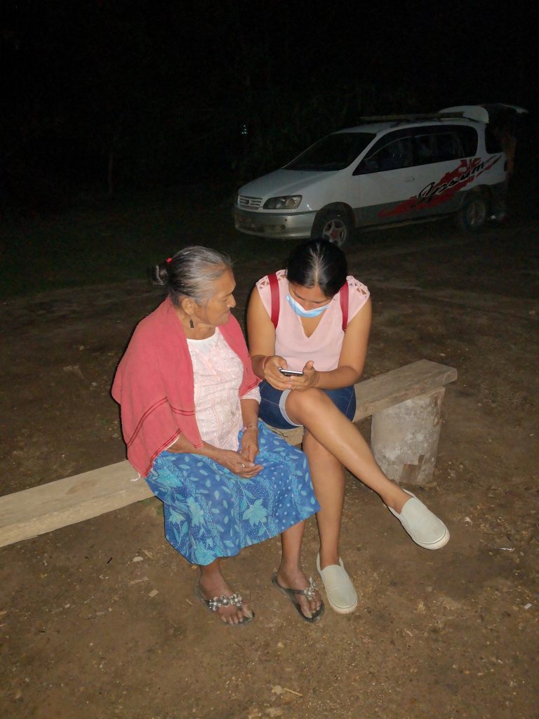 Young field worker interviewing older community member as part of FRMC data collection.