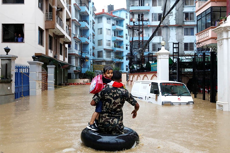 Nepali army carrying a child walks along the flooded colony in Kathmandu, on Friday, July 12, 2019. (Source: The Himalayan Times)