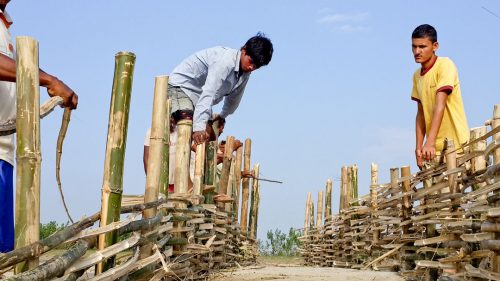 Men building low cost flood mitigation structure using bamboo. Photo by Mercy Corps from the The Managing Risks through Economic Development (M-RED) program in Nepal.