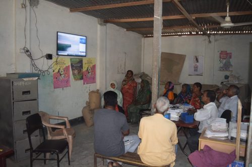 Group of people getting their flood forecast from their digital community weather board