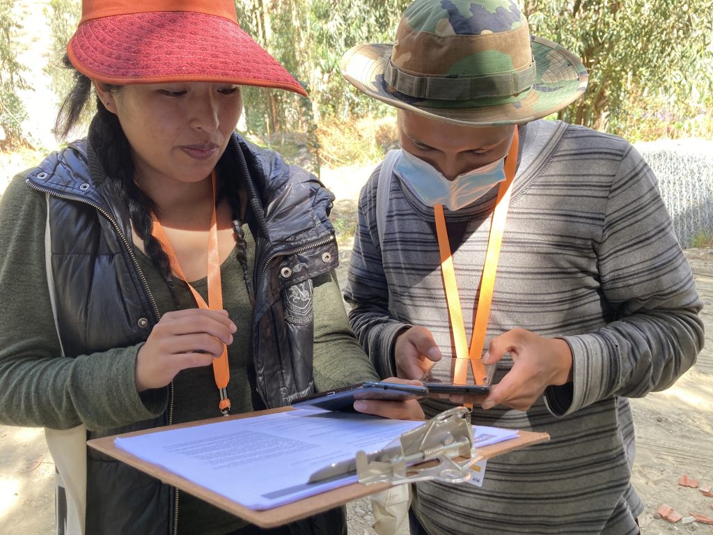 Young field workers on their phones using the FRMC monbile application in Mecapaca, Bolivia.