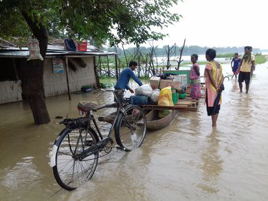 Community members using boats to move grains to safety during flood.